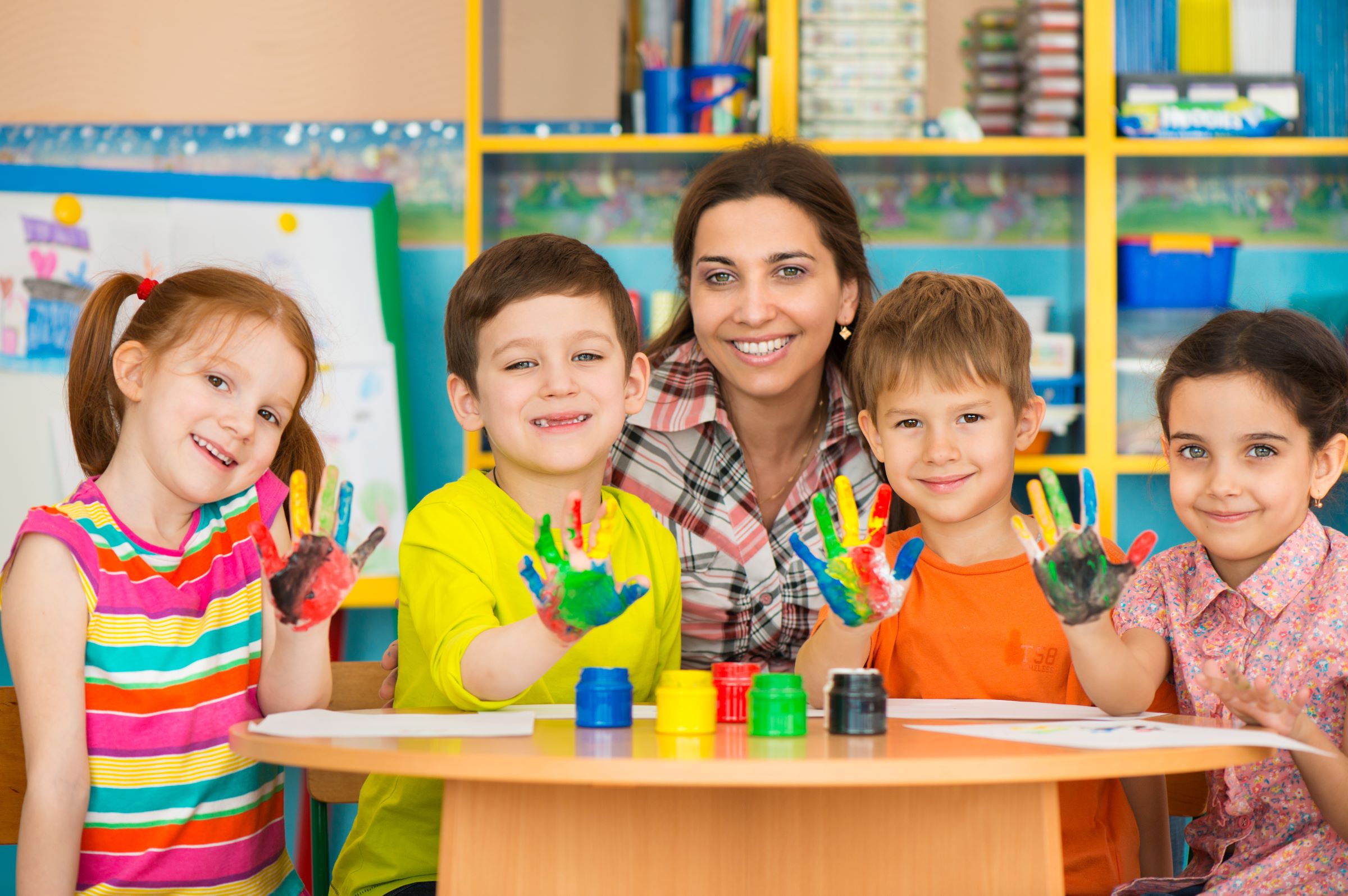 Photograph of teacher with four children in classroom.